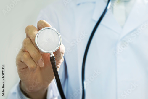 A half-standing doctor, without a face, holding a stethoscope against a white background.,doctor holding a stethoscope,physical examination,health check