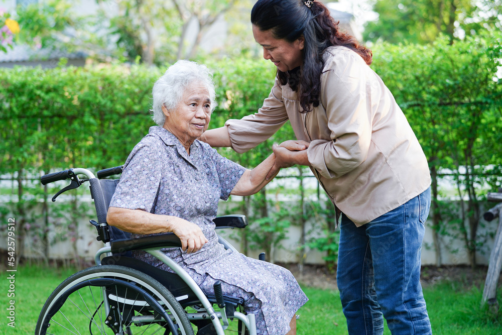 Caregiver help Asian elderly woman disability patient sitting on wheelchair in park, medical concept. Caregiver help Asian elderly woman disability patient sitting on wheelchair in park, medical concept.