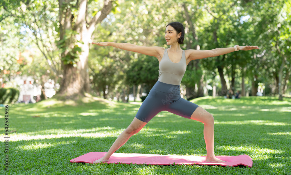Young attractive girl is doing advanced yoga asana on the fitness mat in the middle of a park. Young attractive girl is doing advanced yoga asana on the fitness mat in the middle of a park.