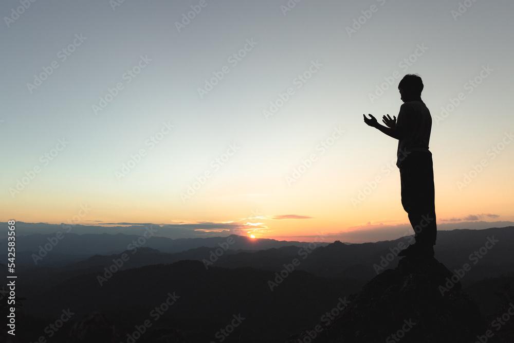 Man praying at sunset mountains, concept vacations outdoor harmony with nature landscape, Travel Lifestyle spiritual relaxation emotional meditating.
