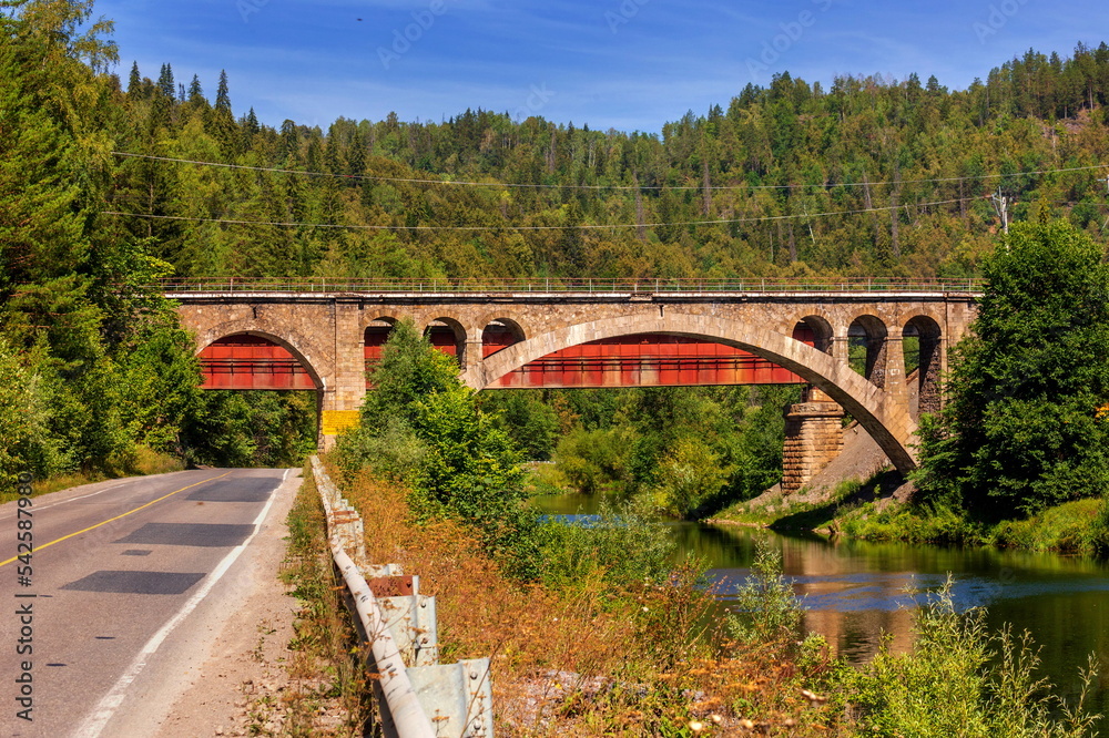 Nikolsky Stone Railway Bridge is one of the main decorations on the road from Sim to Asha on a sunny summer day. Nikolsky Stone Railway Bridge is one of the main decorations on the road from Sim to Asha on a sunny summer day.