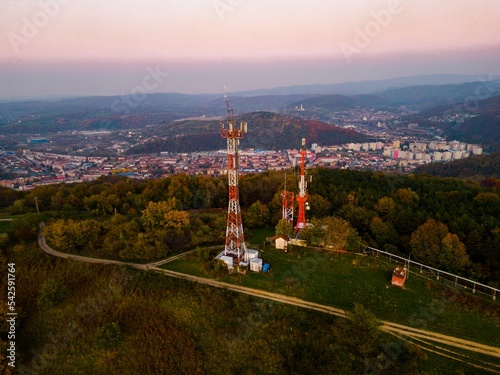 Aerial view of telecommunication tower situated on a hill top, with many cellular antennas which transmits 3G, 4G and 5G signal to phones and other terminals