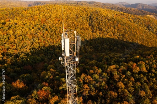 Aerial view of telecommunication tower situated on a hill top, with many cellular antennas which transmits 3G, 4G and 5G signal to phones and other terminals