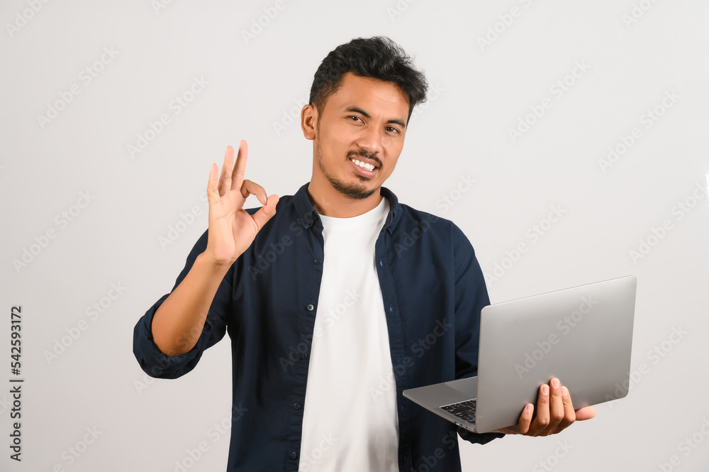 Portrait of a happy asian businessman working on laptop computer isolated over white background Portrait of a happy asian businessman working on laptop computer isolated over white background