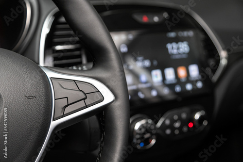 Close up of car steering wheel with function buttons