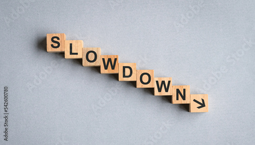 Slowdown, word on wood block. Concept for recession or economy slow down. photo