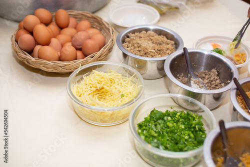 Eggs and vegetables and ground pork are placed on the table to use as ingredients for cooking.