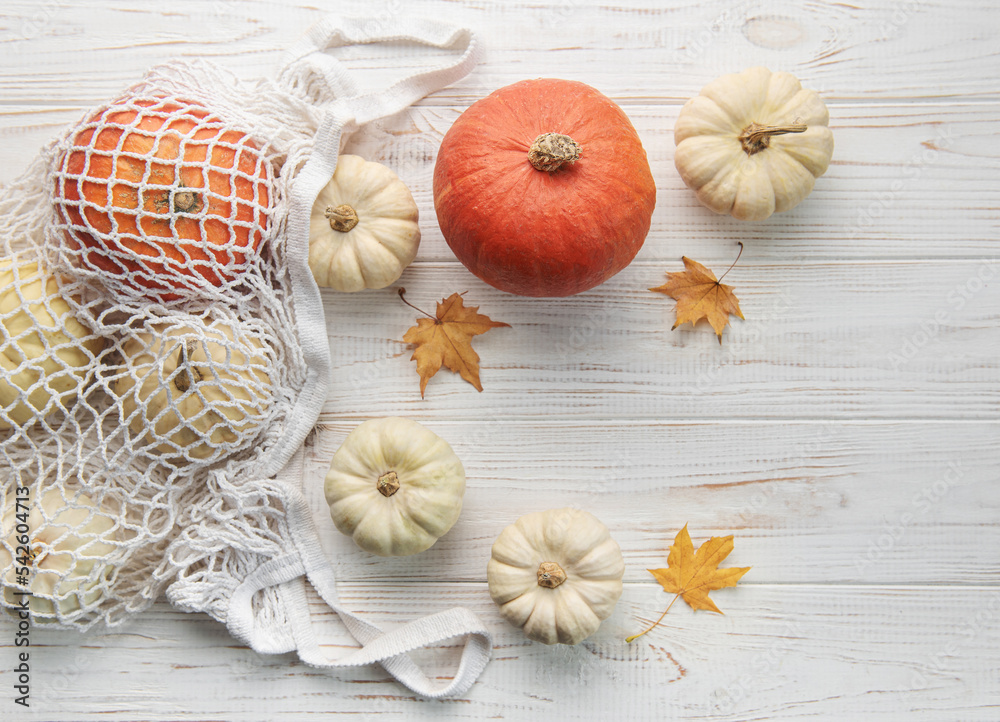 Top view autumn composition with pumpkins in mesh shopping bag