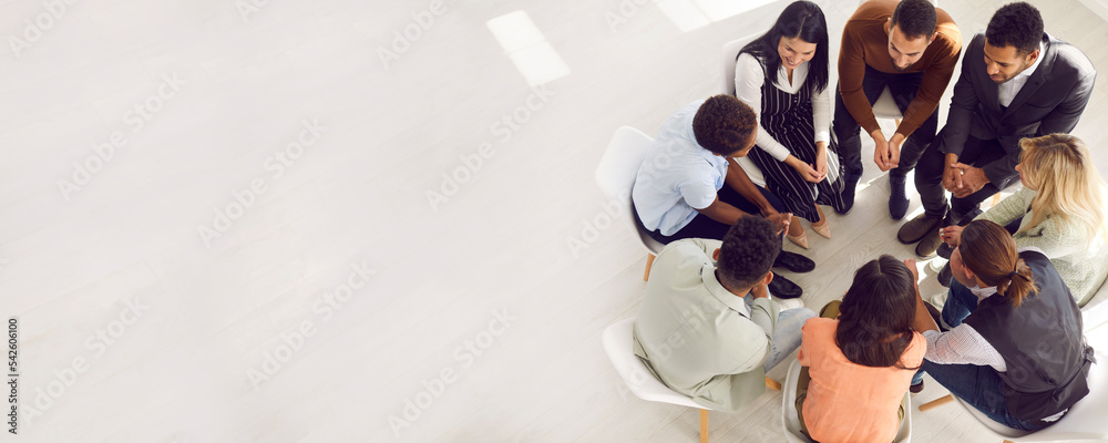 Copy space banner background with coach or psychologist providing professional guidance to group of people. Business team talking while sitting in circle in room with white floor high angle from above - obrazy, fototapety, plakaty 