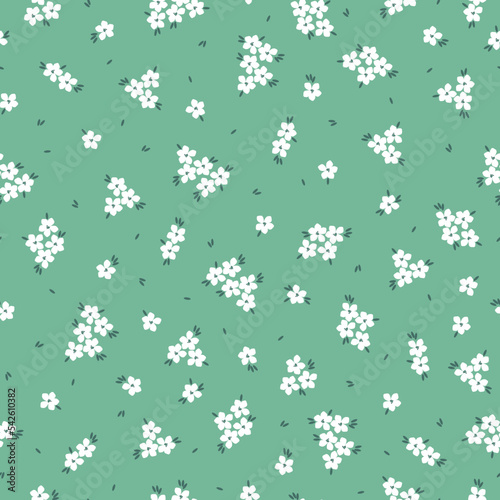 Cute floral pattern in a small flower. Seamless vector texture. An elegant template for fashionable prints. Print with small   white flowers and green leaves. light green background.