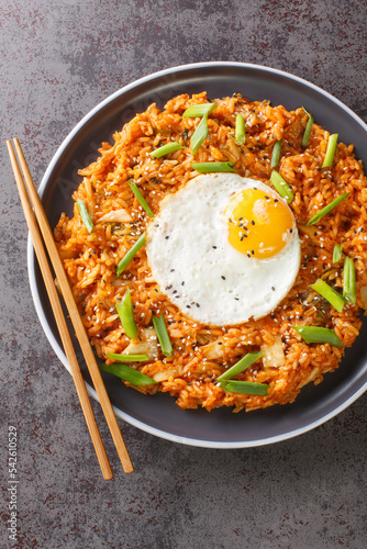 Kimchi fried rice Bokkeumbap is a type of Korean food closeup on the plate on the table. Vertical top view from above photo