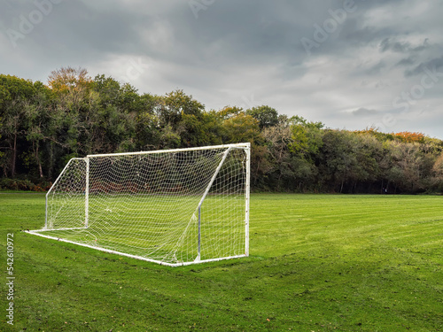 Small soccer goal post on a field. Green trees in the background. Training field for popular sport. Nobody. © mark_gusev
