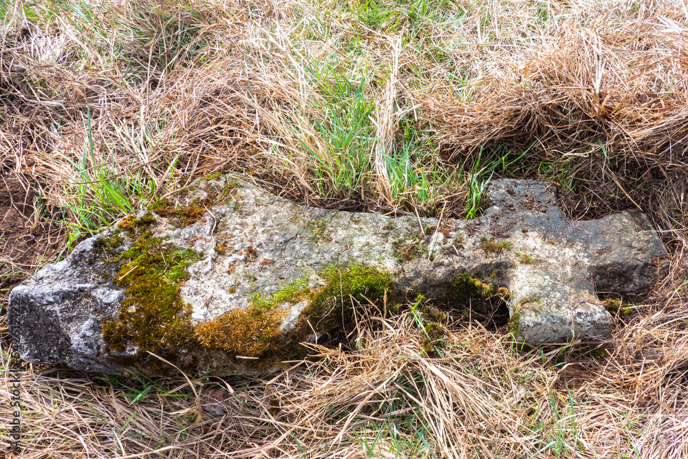 Religious cross lying down in a abandoned graveyard Religious cross lying down in a abandoned graveyard