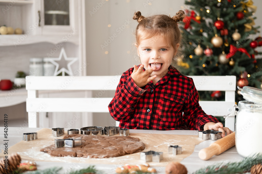 little girl in red pajama cooking festive gingerbread in christmas decorated kitchen little girl in red pajama cooking festive gingerbread in christmas decorated kitchen