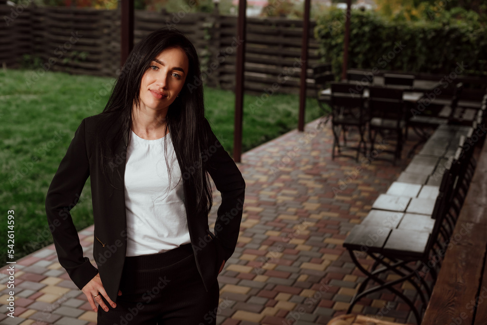 beautiful girl with black hair dressed in a black business suit on the street