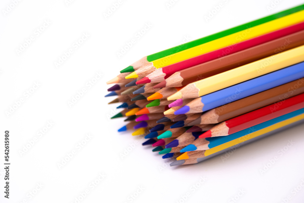 pencils of many colors close-up grouped together laid on a white background pencils of many colors close-up grouped together laid on a white background