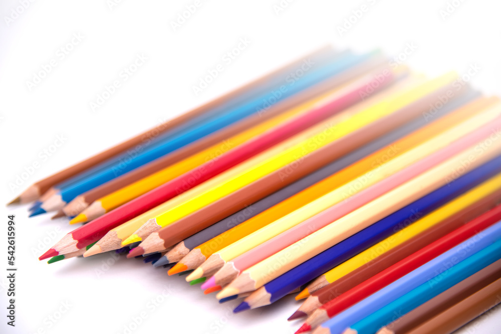 Colors pencils of many colors arranged in a row on a white background 