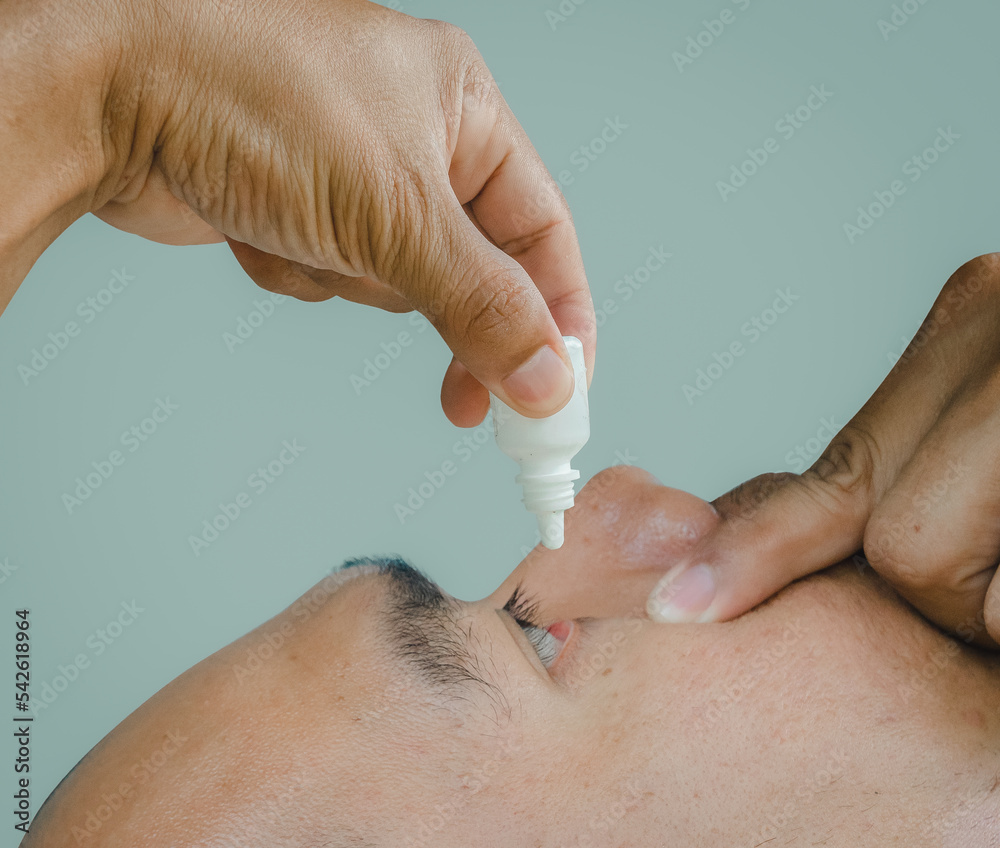 Closeup Of men applying eye drops on inflamed or conjunctivitis