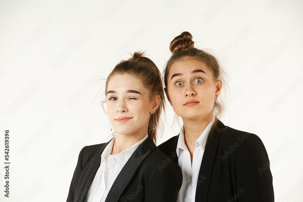 Two girls in office clothes, facial expressions on their faces. Pure white background. The concept of business and corporate relationships in the enterprise. Two girls in office clothes, facial expressions on their faces. Pure white background. The concept of business and corporate relationships in the enterprise.