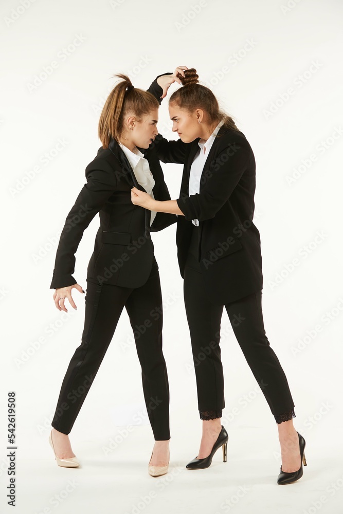 The conflict of two girls in office clothes. Boss and subordinate. Pure white background. The concept of business and corporate relationships in the enterprise. The conflict of two girls in office clothes. Boss and subordinate. Pure white background. The concept of business and corporate relationships in the enterprise.