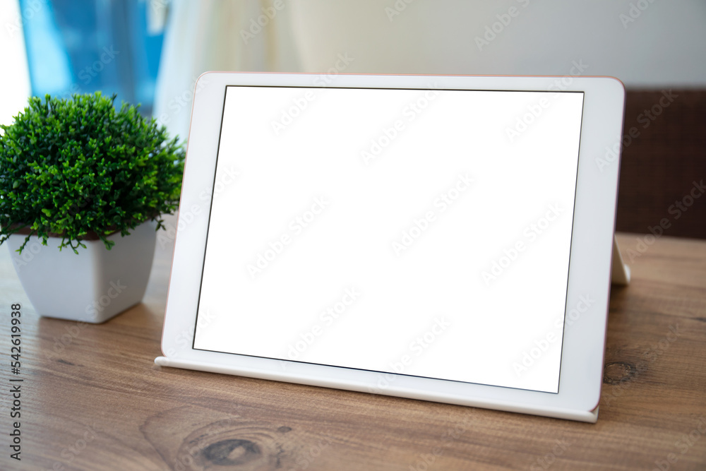 Fototapeta premium white computer tablet with isolated screen on table in cafe