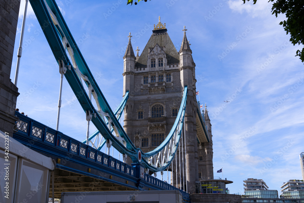 Fototapeta premium Famous Tower Bridge with traffic and pedestrians at City of London on a blue cloudy summer day. Photo taken August 4th, 2022, London, England.