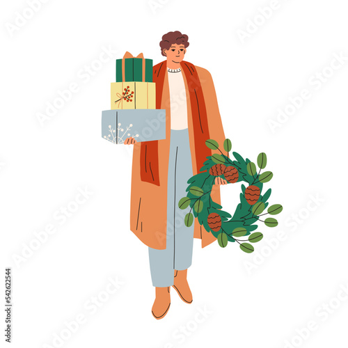 Woman with gift boxes and Xmas wreath during Christmas eve preparations. Happ...
