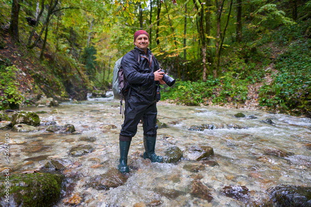 Nature photographer shooting landscapes in a canyon with a river Nature photographer shooting landscapes in a canyon with a river
