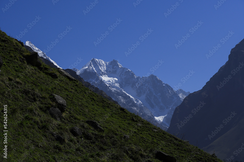 Amazing view of snowcapped mountain peaks landscape. Clear blue sky and snow peaks on a sunny morning. Black peak and other prominent peaks seen during har ki dun trek in Uttarakhand, India. 