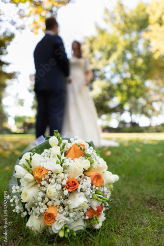 Selective focus on a bouquet and blurred wedding couple