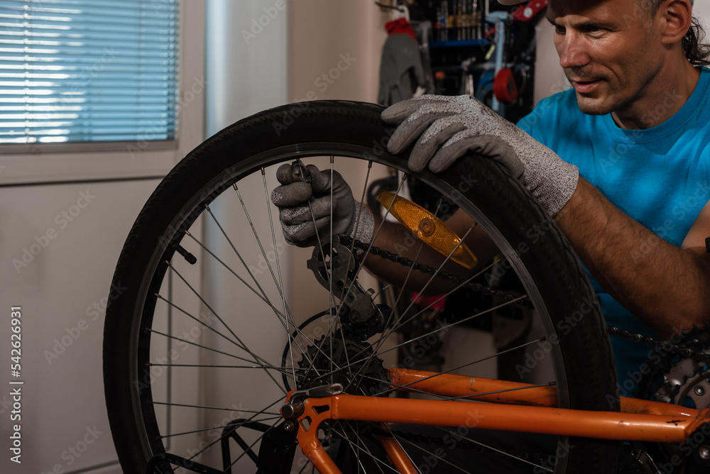Concentrated cycling mechanic checking bicycle wheel spoke Concentrated cycling mechanic checking bicycle wheel spoke