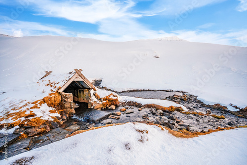 Small hot spring in Hrunalaug, winter Iceland. Bathes in a hot spring in the open air with a gorgeous view of the snowy mountains. photo