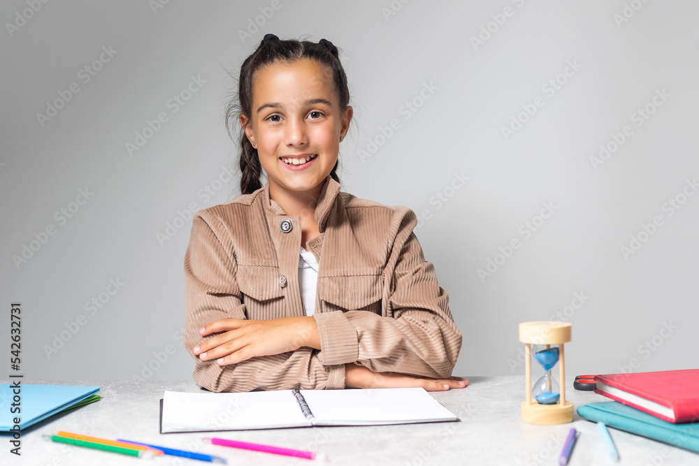 caucasian girl sitting at the desk and writing in a notebook and doing homework. caucasian girl sitting at the desk and writing in a notebook and doing homework.