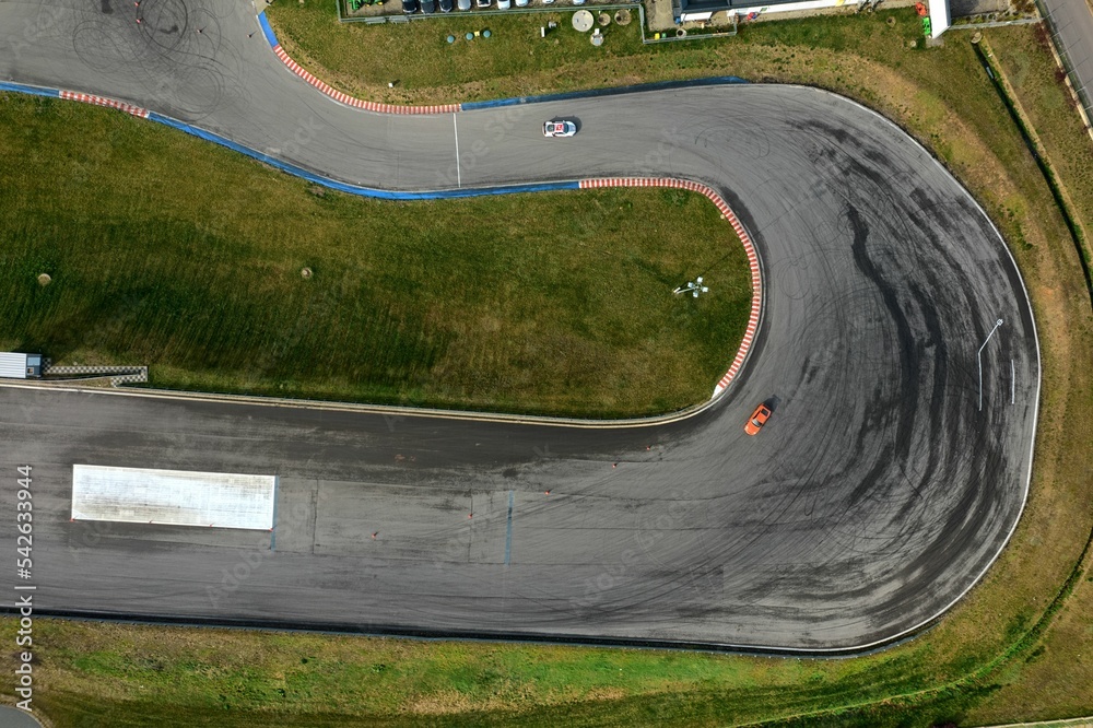 car racing track and racing cars as seen from above from a drone. Fast, luxury cars.