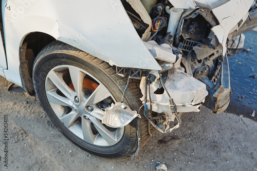 Front of white car get damaged by accident on the road