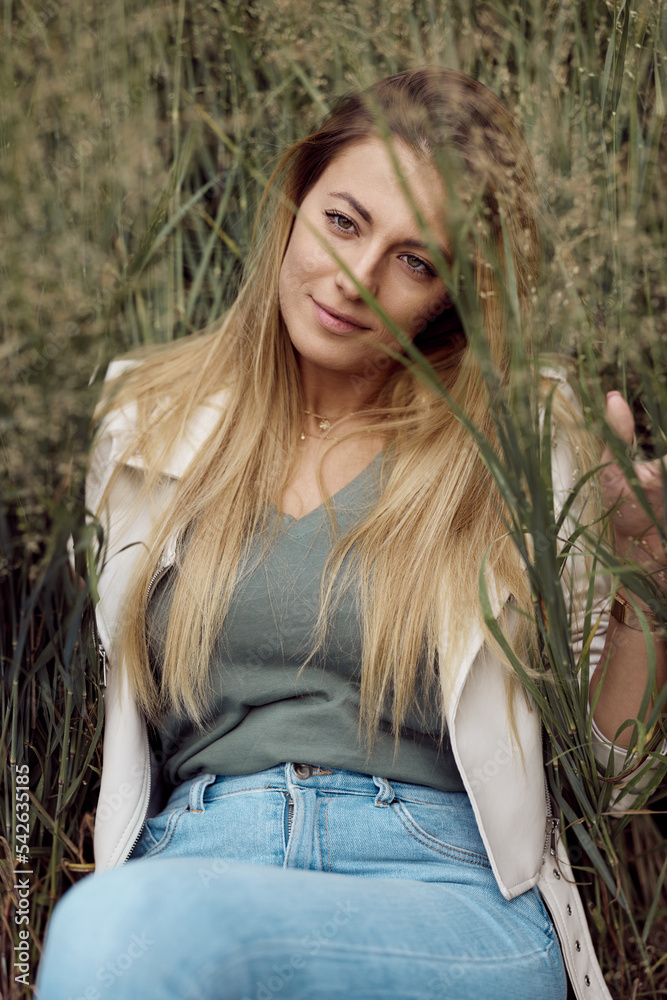 A beautiful woman posing in grass. A beautiful woman posing in grass.