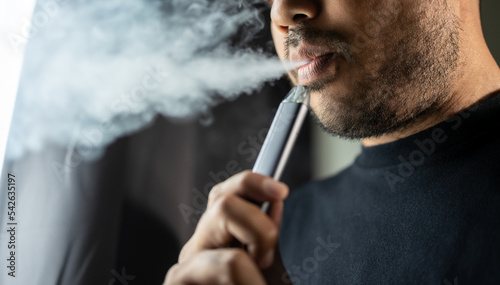 Quadro su tela Close-up mouth of man smoke inhaling, breathing and smoke electronic cigarette