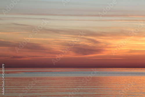 Sunsetting sky above calm sea during the dusk. Selective focus © Anna