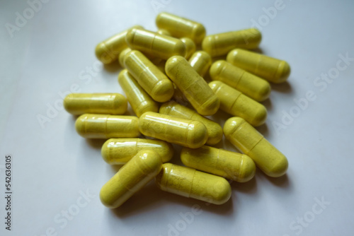 Closeup of heap of greenish yellow capsules of quercetin dietary supplement photo