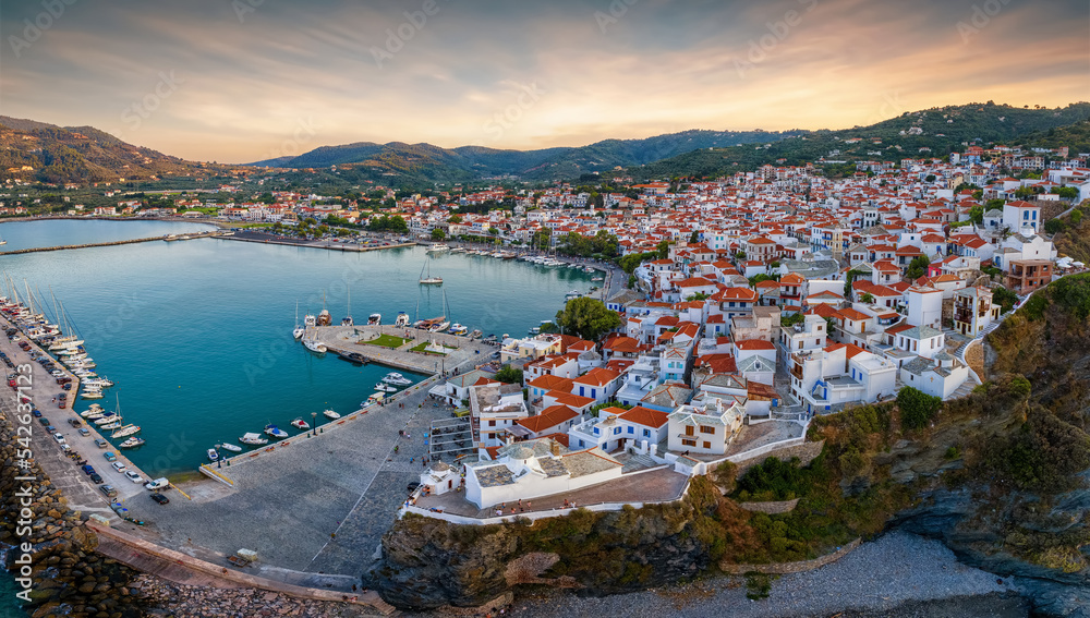 Panoramic aerial view of the town of Skopelos island with the traditional, red roofed houses during a calm summer sunset, Sporades, Greece