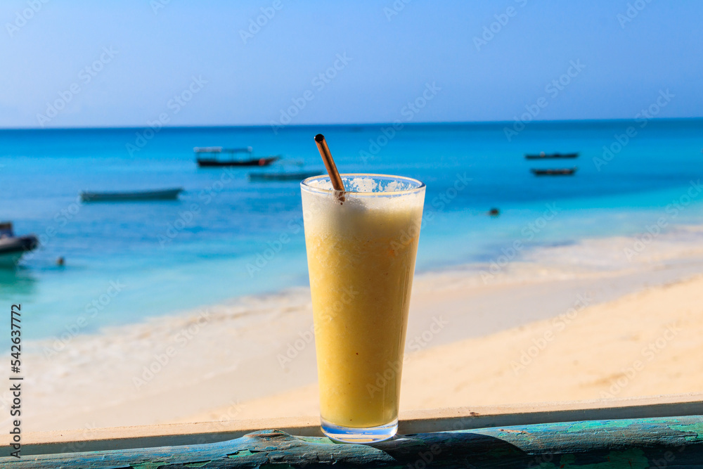 Glass of fresh juice by the ocean. Tropical vacations concept Glass of fresh juice by the ocean. Tropical vacations concept