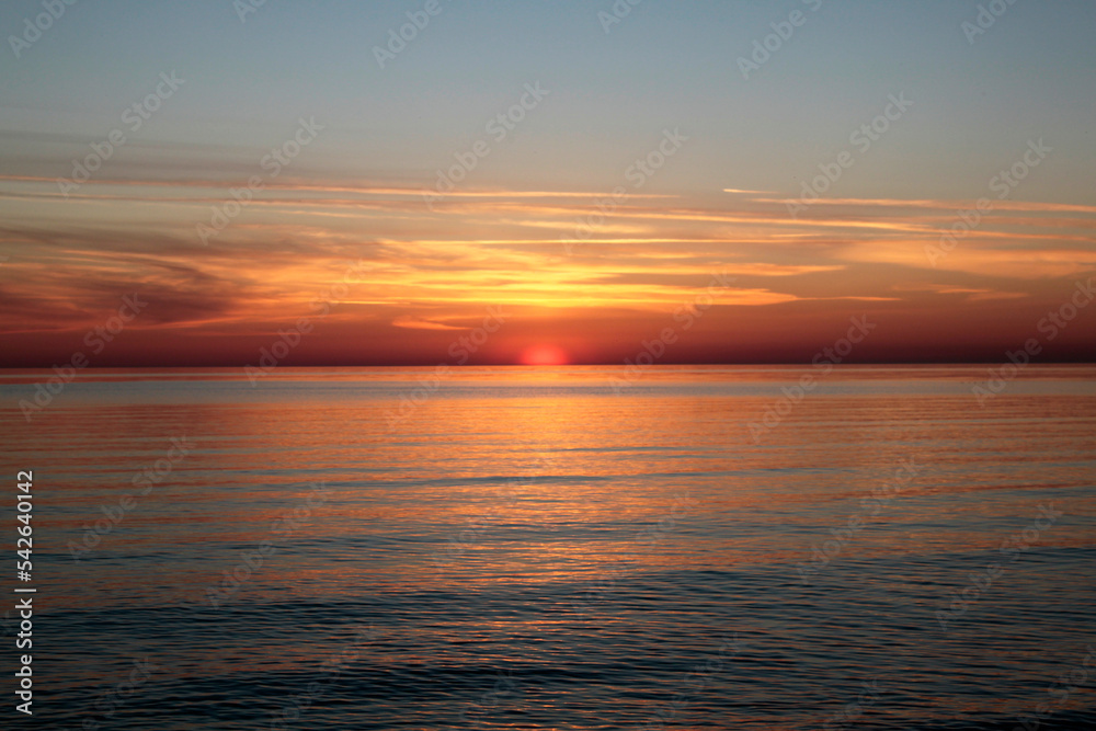 Sunsetting sky above calm sea during the dusk. Selective focus