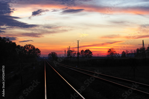 Tory kolejowe wieczorem po zachodzie słońca, kolorowe niebo.
