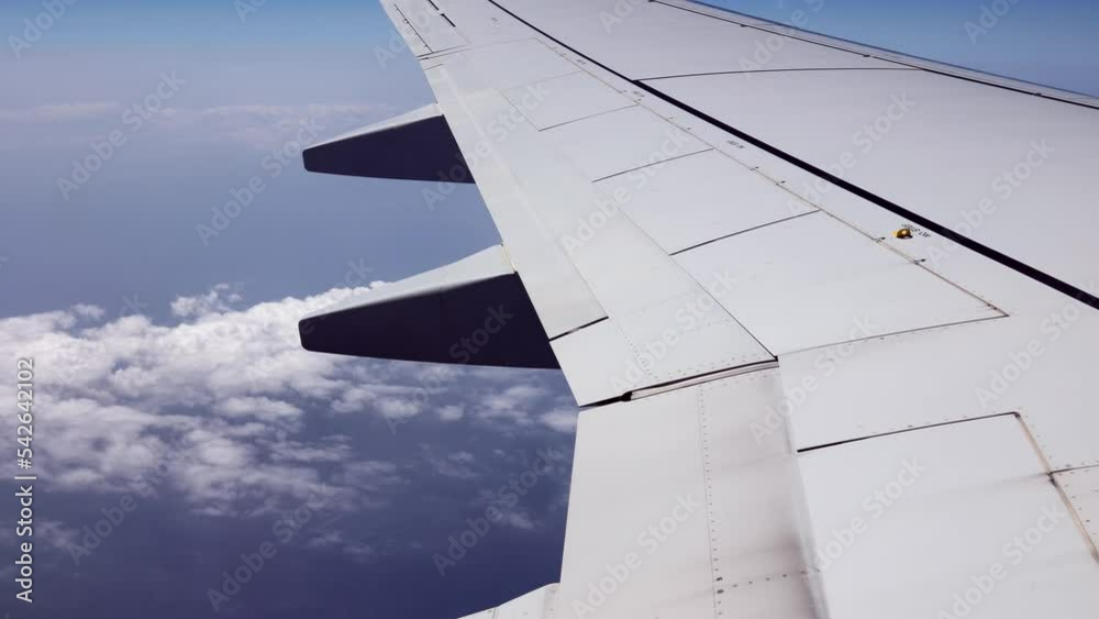 Looking Outside a Window of an Aircraft Cabin: White Airplane Wing and Clouds Looking Outside a Window of an Aircraft Cabin: White Airplane Wing and Clouds