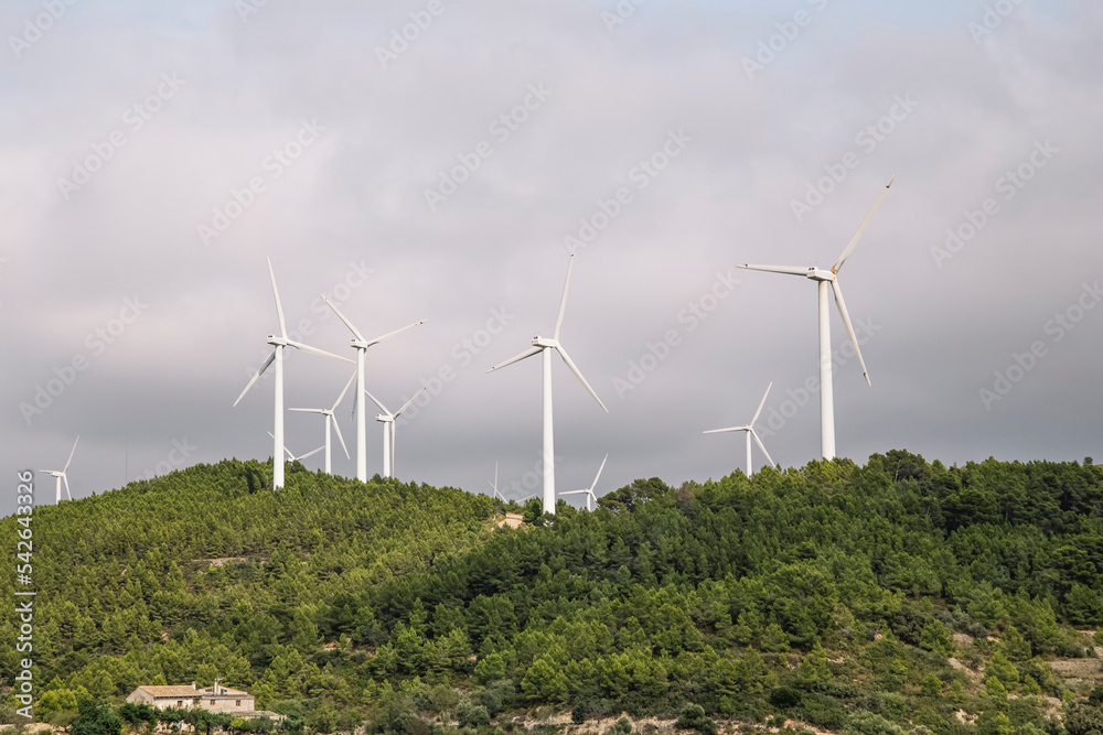Windmills In Field Against Cloudy Sky Windmills In Field Against Cloudy Sky