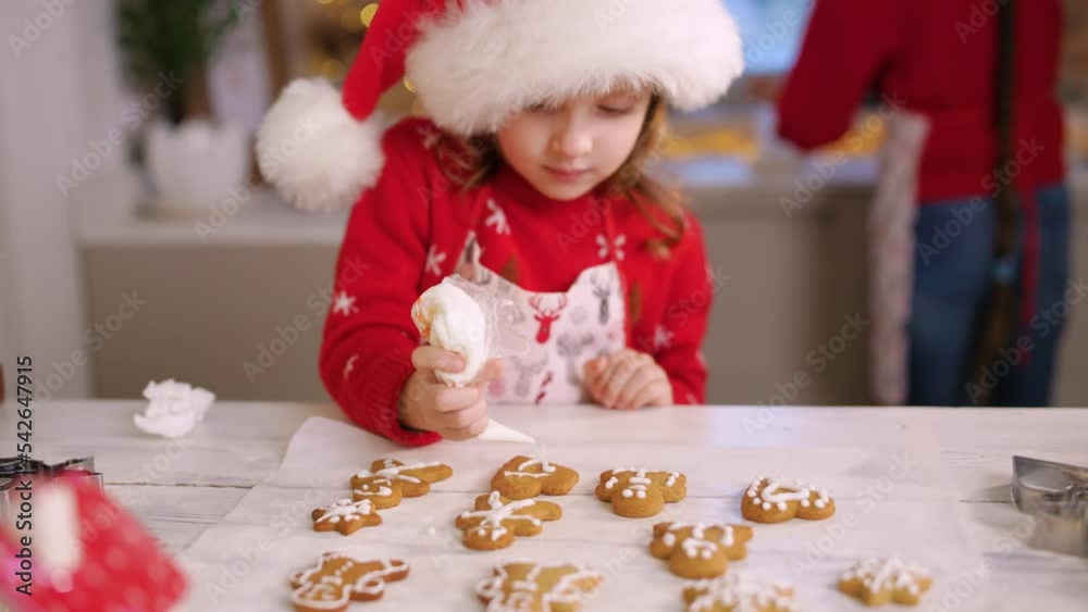 The child in Santa hat is uplifted by the preparation to make ginger cookies for the Christmas holiday.