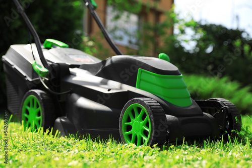 Lawn mower on green grass in garden