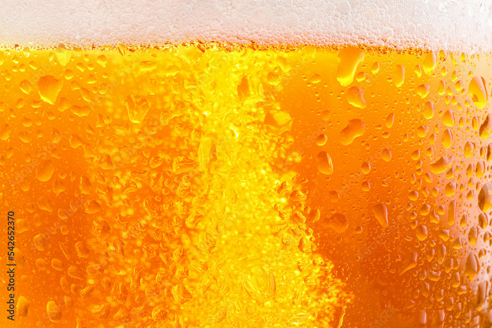 Glass of tasty cold beer with foam and condensation drops as background, closeup Glass of tasty cold beer with foam and condensation drops as background, closeup