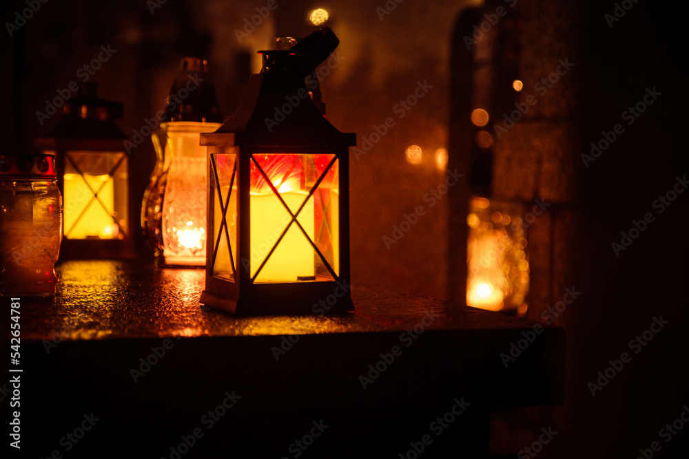 Votive candle burning at a cemetery at night