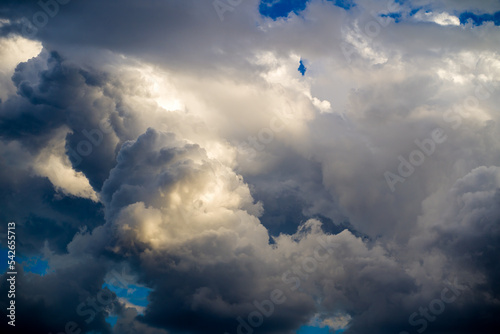 Fotografia Ominous dark sunlit clouds in blue sky